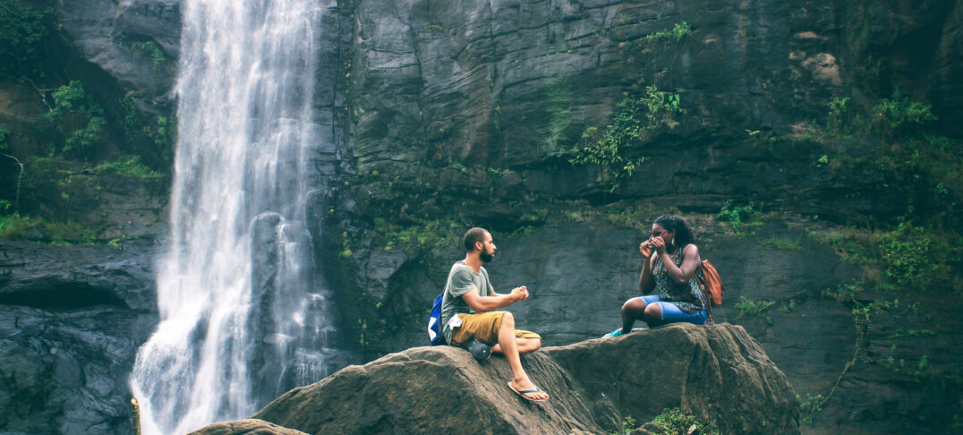 Students sitting by waterfall are earning an online Counseling Masters degree.