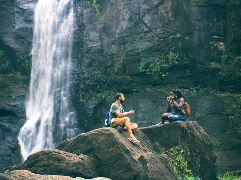 Students sitting by waterfall